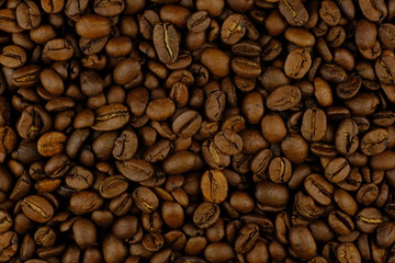 Coffee bean pile background closeup. Macro coffee bean heap.