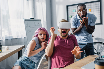 Selective focus of multiethnic business people with vr headset in office