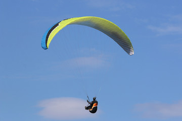 Paraglider flying wing in a blue sky