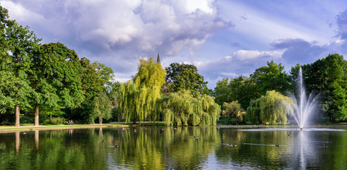 beautiful city gardens and park with a pond and geyser fountain - obrazy, fototapety, plakaty