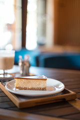 Delicious caramel cheesecake on a plate on a wooden table in a cafe