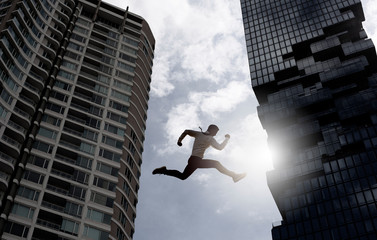 Young businessman jumping high, Work, job, or successful business concept. Cityscape background.