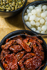Italian sun dried tomatoes with garlic, bright wooden table background