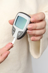 close-up female hands, woman makes test with lancet pen and glucometer, Medicine, glycemia, healthcare and medical concept