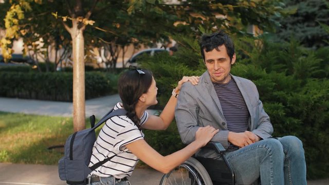 Woman talking with a man in a wheelchair