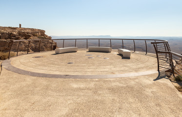 A vantage point at dawn at a public sculpture park in the desert, on a cliff above the Judean...