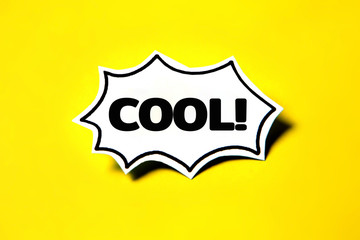 cool speech bubble on white paper isolated on yellow paper background with drop shadow.