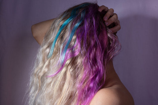 Portrait Of A Girl Covering Her Head With Multi Colored Hair. On A Pink Background. Beauty Girl, Coloring In Pink Hair, Purple Shade Of Female Hair. Turquoise Hair Color Of A Young Girl