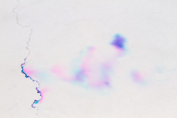 Old water damaged white paper with multicolored pastel color spots background