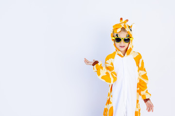 a cheerful boy in a bright orange giraffe costume holds his hand on a white isolated background, space for text