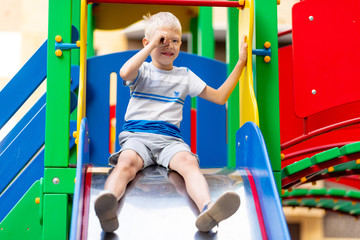 Obraz premium happy baby boy 5-6 years old playing on the Playground in the yard in the summer. Children's lifestyle