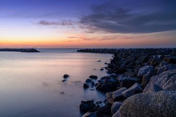 Fototapeta na wymiar beautiful sunset on the coast of Rugen Island in Germany long exposure with a rock jetty