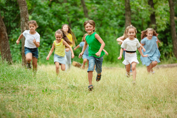 Memories. Kids, children running on green forest. Cheerful and happy boys and girs playing,...