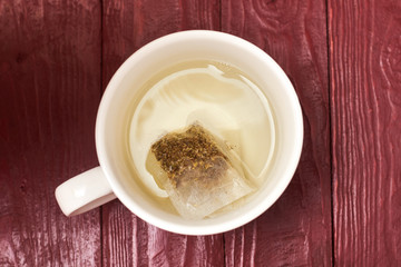 Tea bag in a white cup. Making delicious herbal tea.