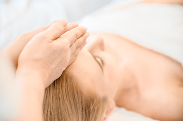 Obraz na płótnie Canvas Beautiful woman receiving head and facial massage in spa salon. Concept of body health care and traditional thai massage relax