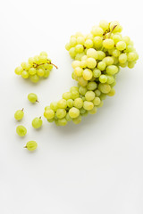 Green grape without leaves on white background. Flat lay. Summer food concept.