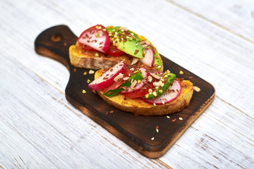 Toasts with vegetables, avocado, tomatoes, a set of seeds on a white background. Healthy food, diet concept.
