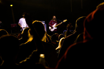 Live music concert, night life and crowd people, standing and listening music young adult people.