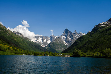 Naklejka na ściany i meble amazing deep mountain lake among rocks and peaks with snow.North Caucasus. Dombai