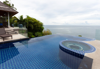 Swimming pool overlooking view andaman sea and clear sky background,summer holiday background concept.