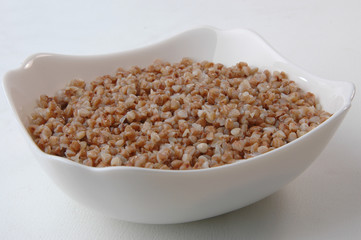 groats in plate on white
