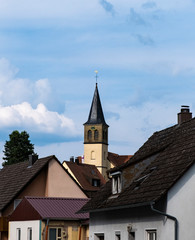 Fototapeta na wymiar German village church and rooftops on a sunny summer day. Taken in Dentlein Am Forst, Germany.