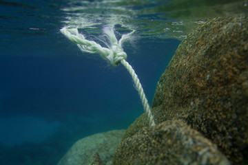 rope underwater with rocks
