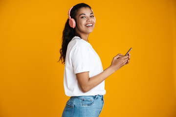 Image of happy african american woman smiling and using mobile phone