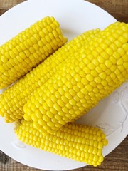 Boiled corn on a white plate macro