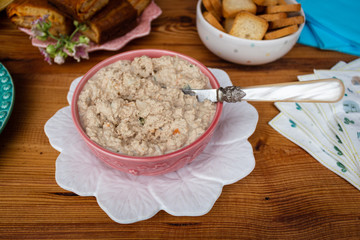 Homemade tuna pate in a vintage bowl on a rustic wooden table. Party concept.