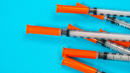 Insulin vial and syringe on blue background. Health care, doctor, clinic or hospital, medical concept. World diabetes day. Ready for vaccine injection. Pain treatment, illegal use, vaccination