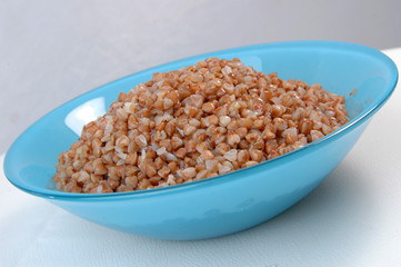 groats in plate on white