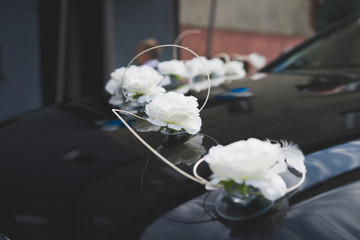 Ozdoby weselne na aucie. Samochód ślubny przystojony w kwiaty.  Maska auta w dekoracjach...