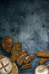 Different homemade breads on a dark table background frame