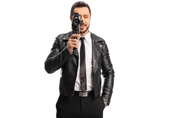 Man in a leather jacker recording with a vintage camera recorder