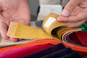 Hands browsing soft velvet samples as part of making the right decision to select the correct color