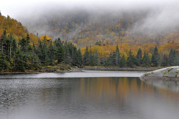 Fototapeta na wymiar Tranquil New England scene. Autumn colors and morning fog over peaceful Beaver Pond in remote Kinsman Notch New Hampshire.