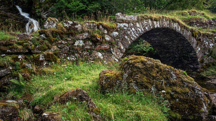 A packhorse bridge crossing a tributary below a waterfall on the south bank of the River Lyon. This is locally known as the Roman Bridge, though actually seems to date back to the 1600s or 1700s.