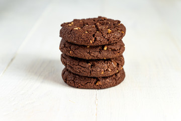 Stuck of Homemade american chocolate cookies with nuts on white wooden background. Fresh pastry.