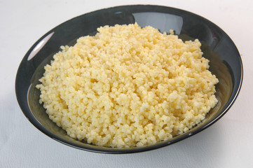 groats in plate on white