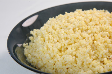 groats in plate on white