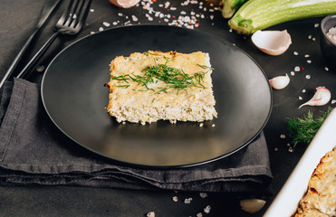Zucchini casserole on dark background. Dietary, low-calorie, healthy food. Homemade Casserole from squash with chicken and eggs.