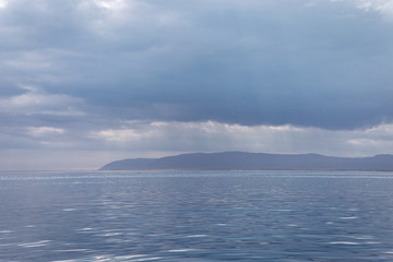 same tones of blue water and sky with the land in the distance