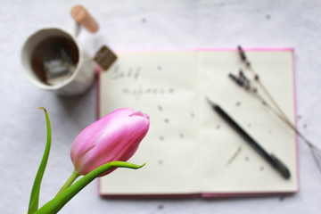cozy breakfast with lemon tea and pink lavender tulip and notebook for reflection