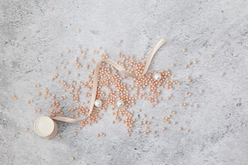 Pink  beads scattered on a marble background close up.