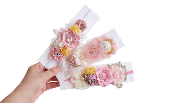 A hand holding bouquet of flowers made out of fabric cloth textile in beautiful pastel colors placed on card stock paper that can be used as hair accessory, decoration, and embellishment