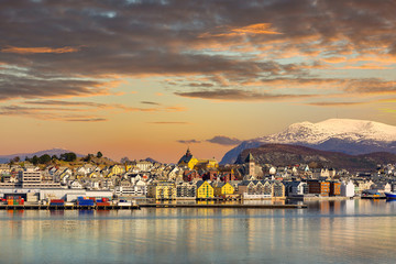 Architecture of Alesund town reflected in the water at sunset, Norway