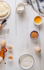 Ingredients for baking and Breakfast with eggs, flour, sugar, milk and butter on a white wooden background. Delicious and healthy food. Flat lay.