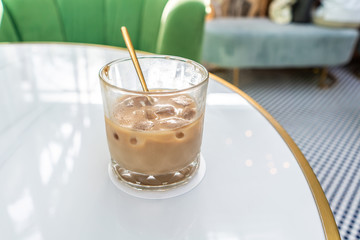 Ice coffee in a tall glass with milk poured over