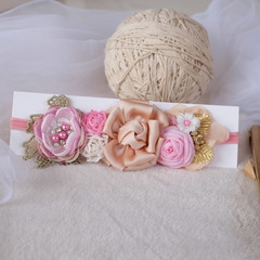 Fototapeta na wymiar A bouquet of flowers made out of fabric cloth textile in beautiful soft pastel colors placed on card stock paper that can be used as hair accessory, decoration, and embellishment
